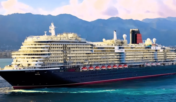 Cunard Queen Anne luxury cruise liner sailing with towering mountains in the background